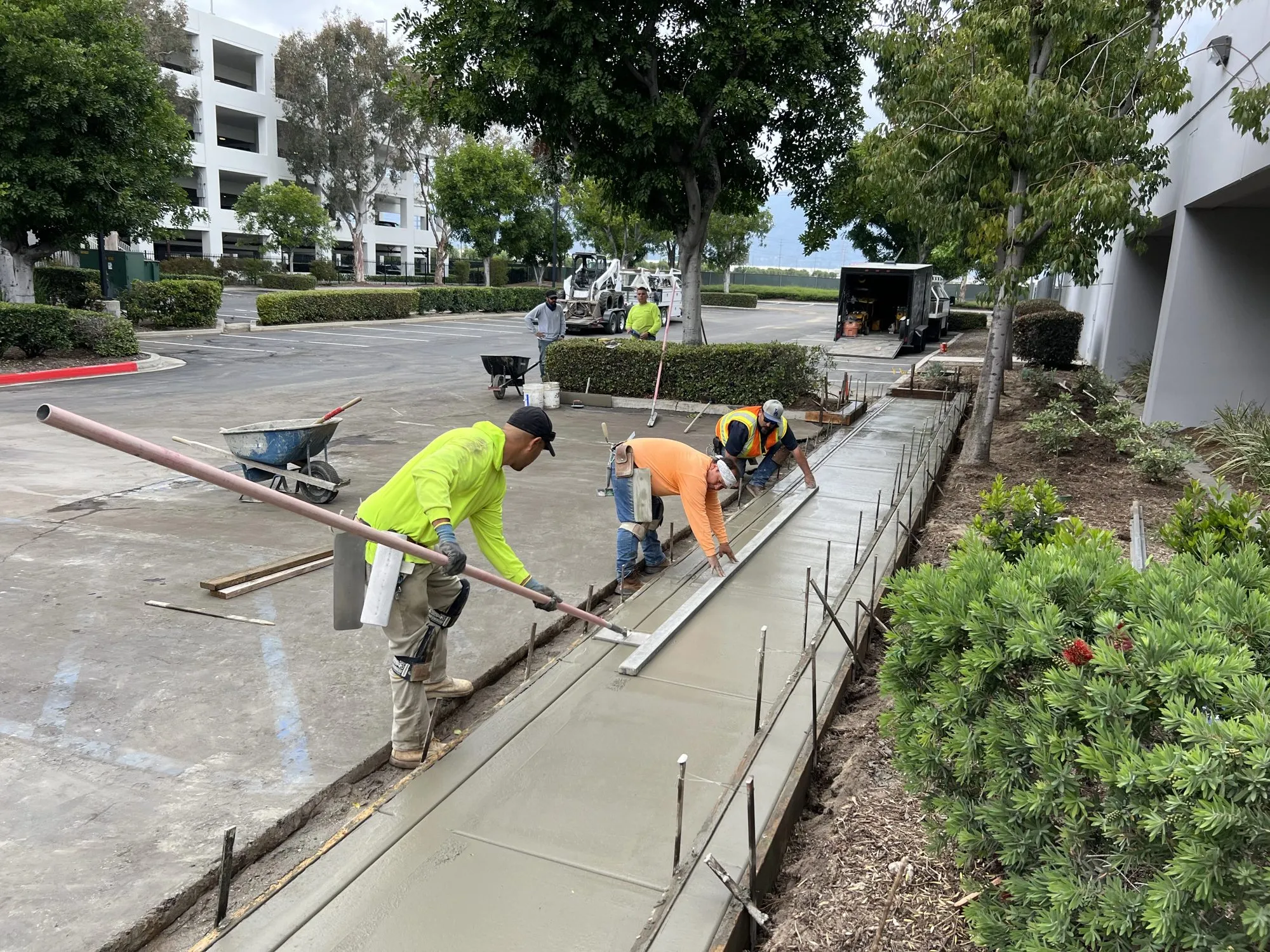 Crew forming and finishing a new concrete sidewalk